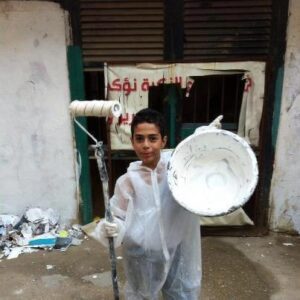 smiling boy with large white paintpot and roller