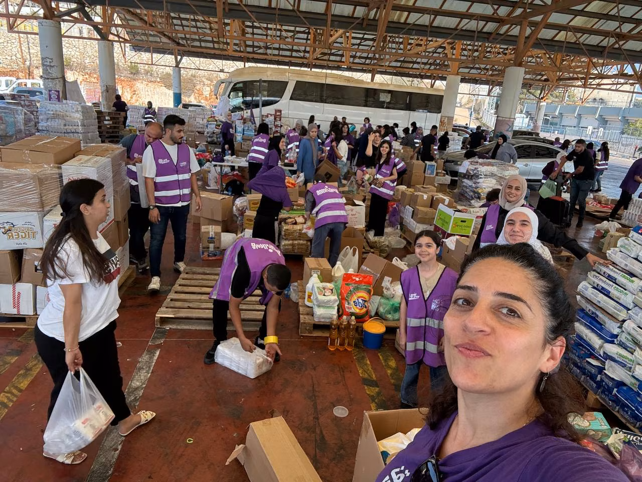 Men and women in purple tabards organise boxes