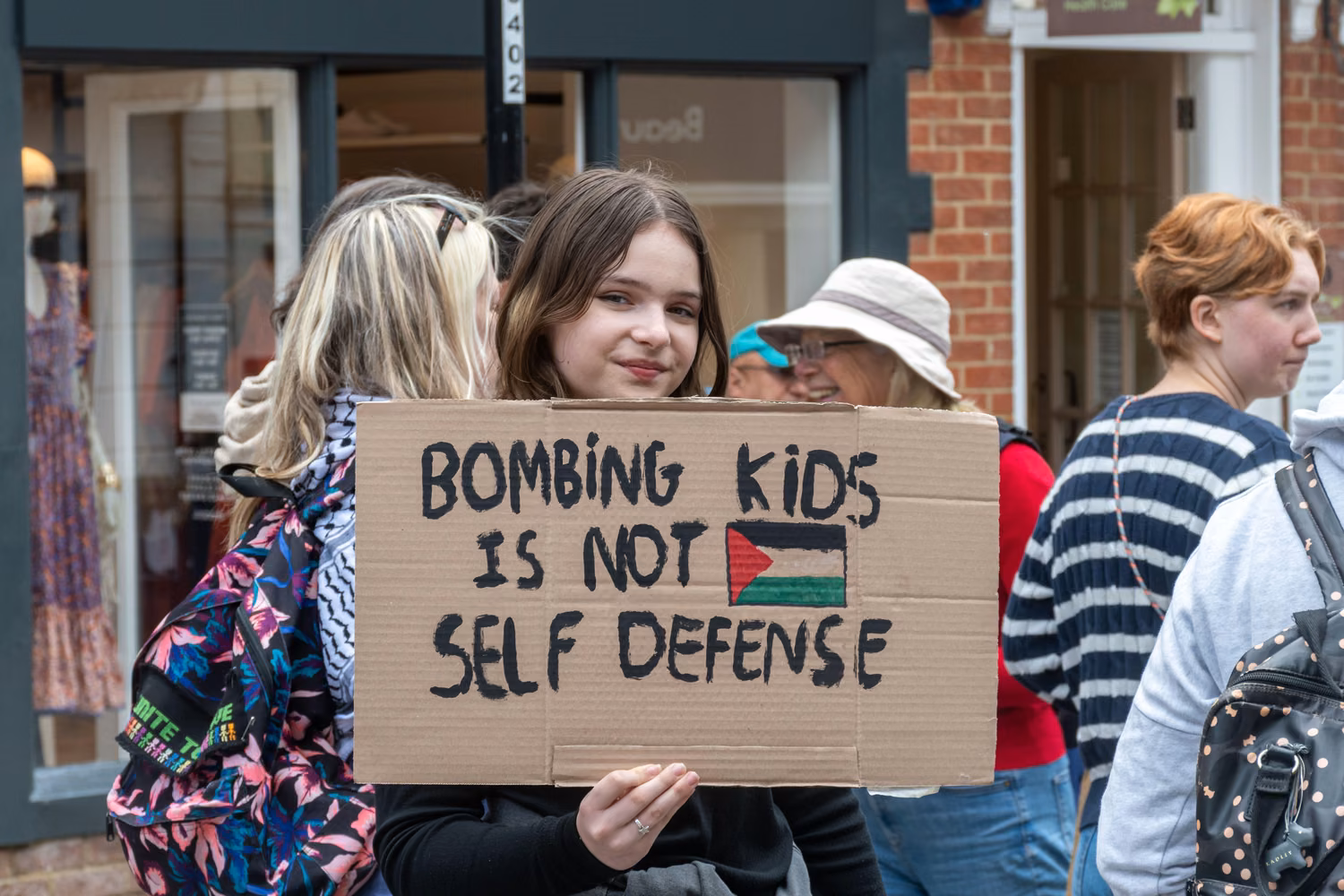 Girl holding a home made placard "Bombing Kids is not Self-Defence: It is still Gaza