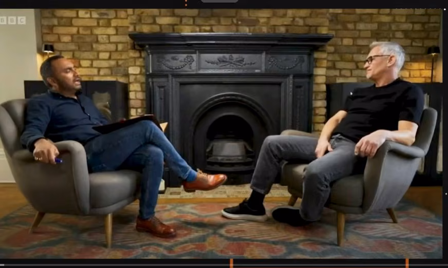 Two men in armchairs face each other