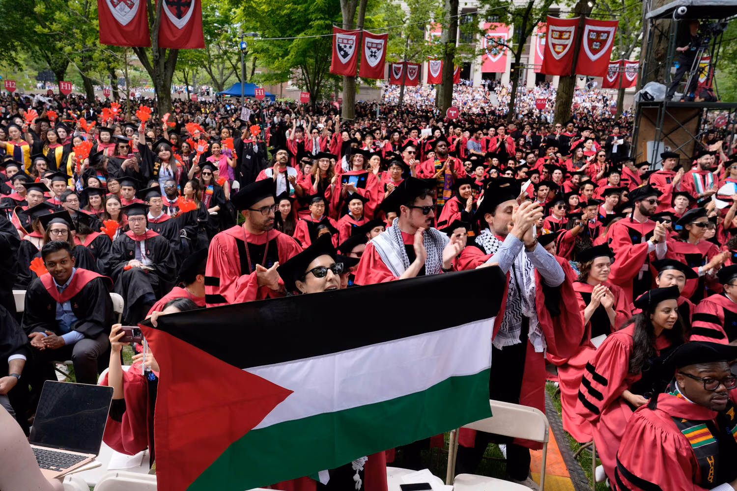 2X86G78 A student holds up the flag of Palestine as the 13 students, who have been barred from graduating due to protest activities, are recognized by a student address speaker during the commencement in Harvard Yard at Harvard University, Thursday, May 23, 2024, in Cambridge, Mass.
