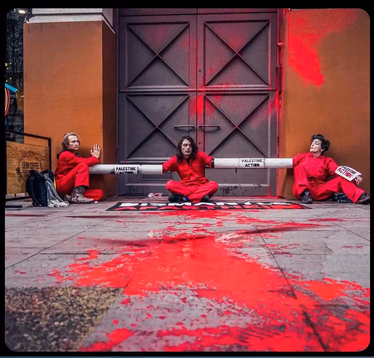 three people dressed in red seated in front of heavy door