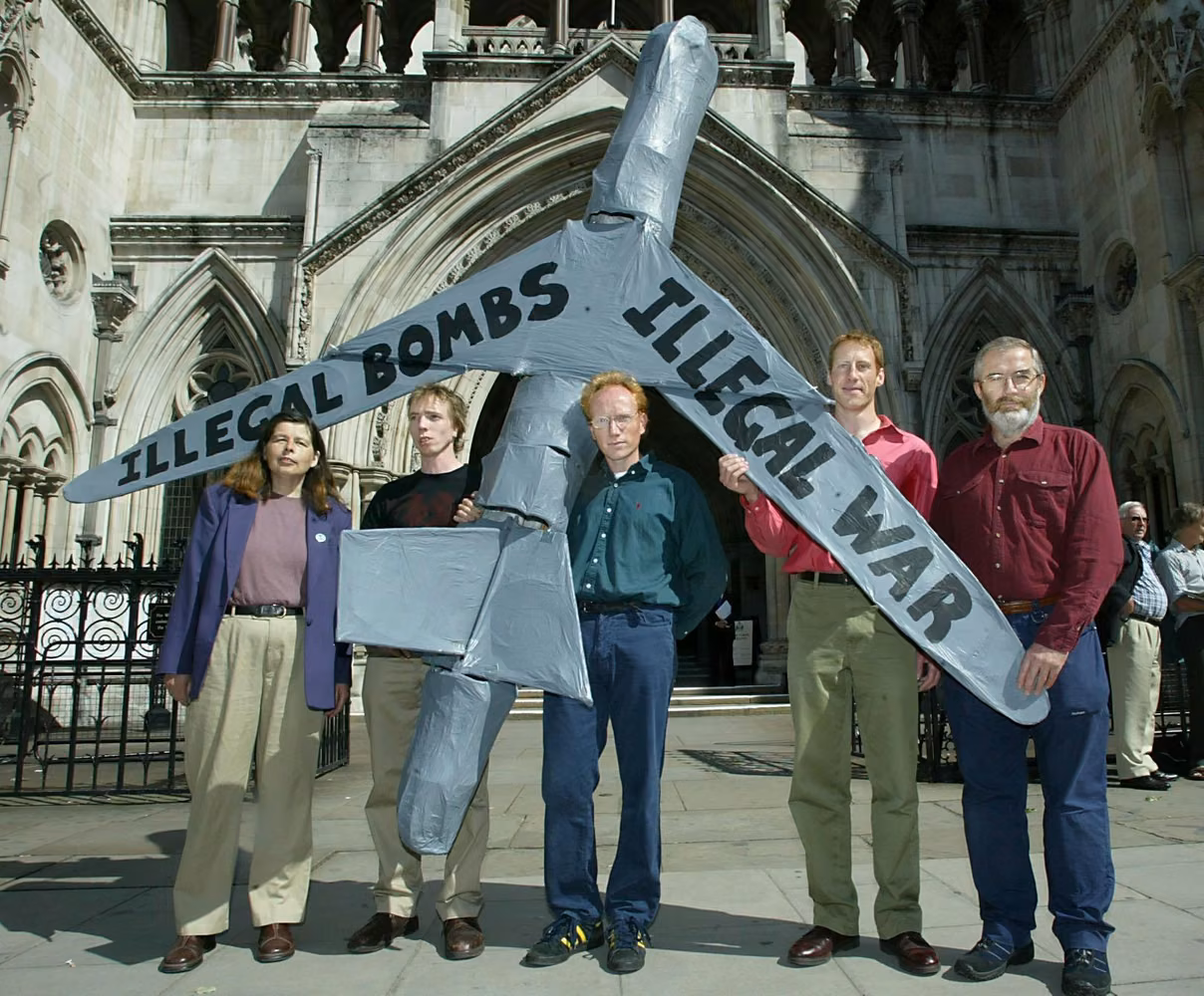one woman and four men hold a large model airplane in front a court building